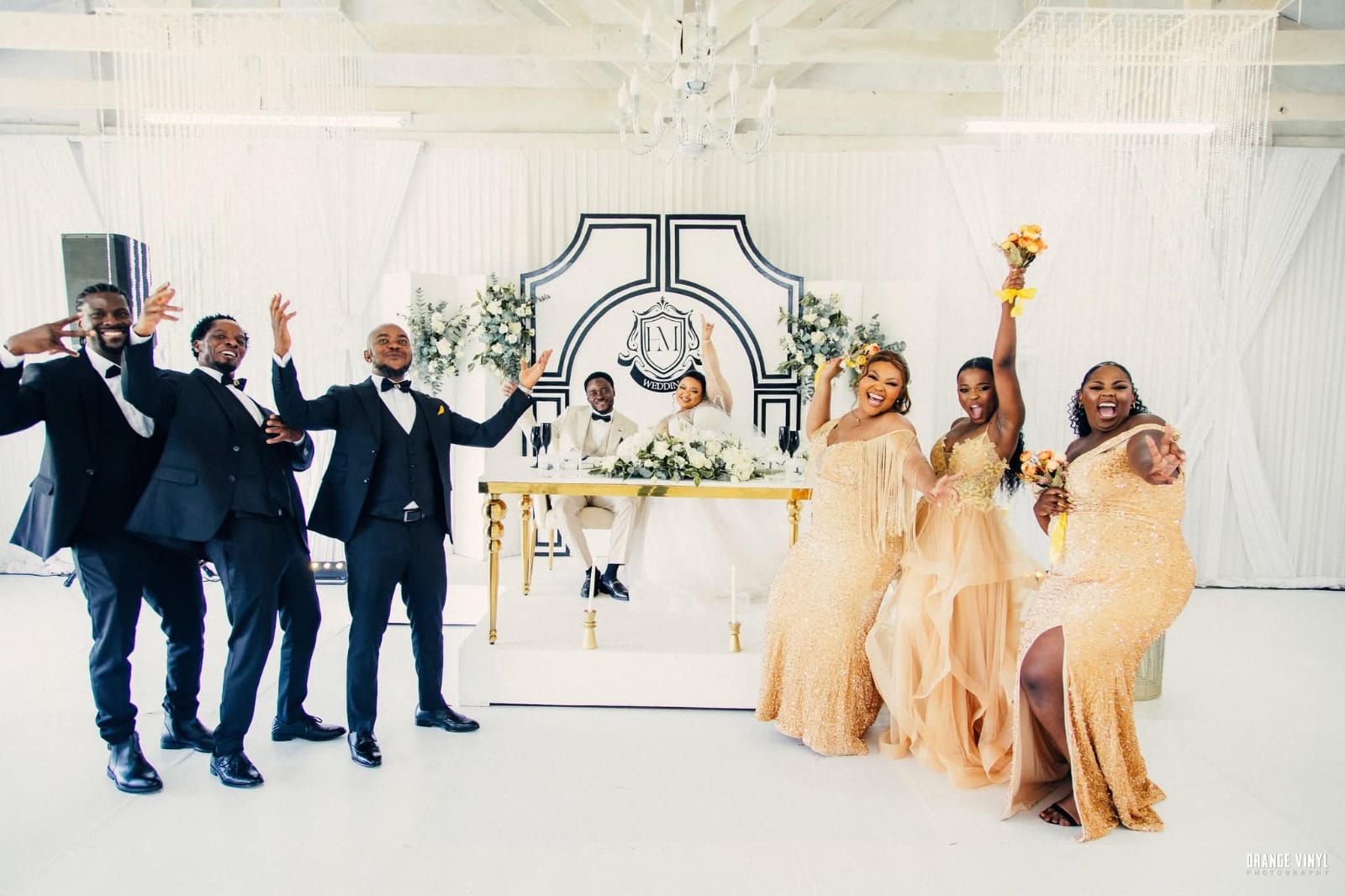 Bridal party celebrating and cheering at the reception sweetheart table