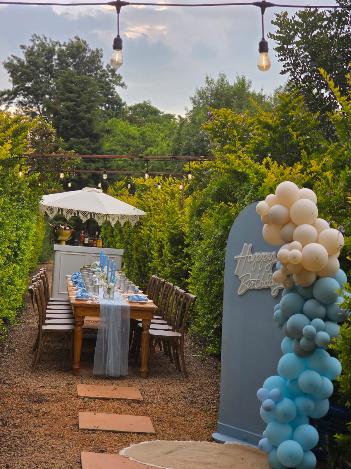Garden celebration setup at Muano Functions Venue with styled long table and balloon arch